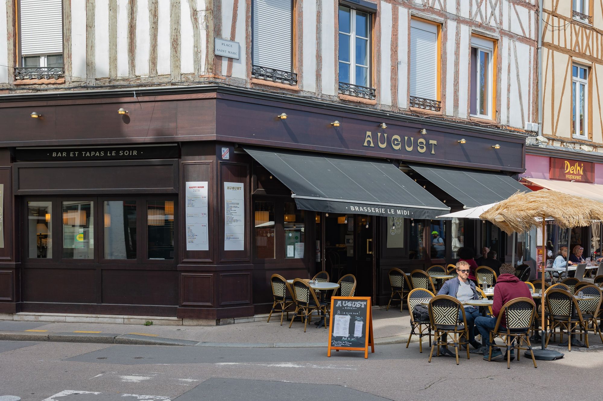 La façade d'August et sa terrasse à l'angle de la place Saint-Marc, entre les colombages de Rouen